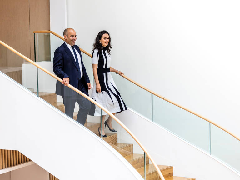 Male and Female Lazard Colleagues Walk Down Set of Stairs