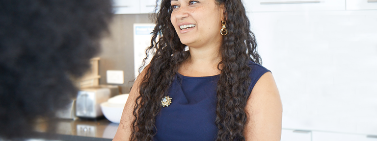 Female Lazard Colleague Smiling and Talking in Kitchen