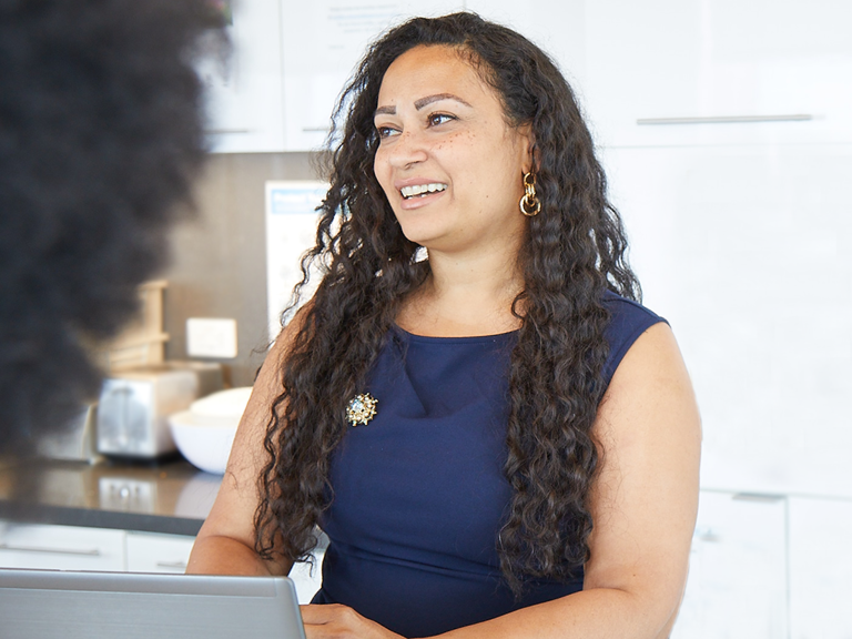 Female Lazard Colleague Smiling and Talking in Kitchen