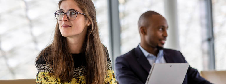 A woman thinking with a man in the background