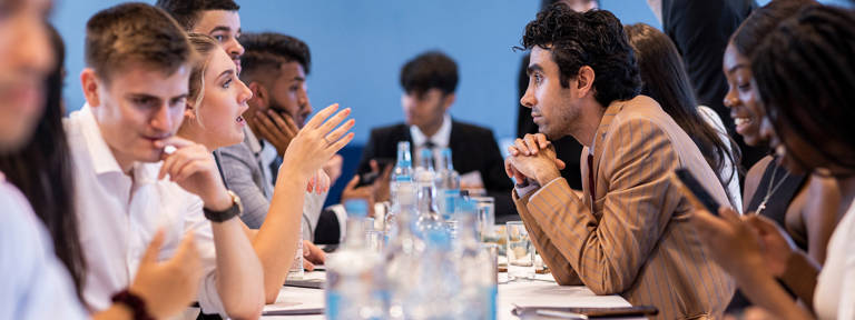 Group of Lazard Interns Talking at Long Table