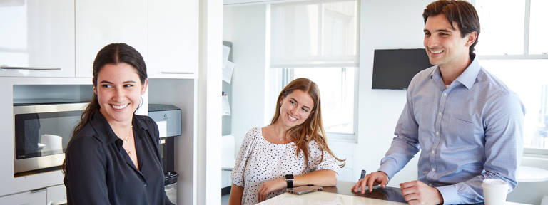 2 Female 1 Male Lazard Colleagues in Pantry Laughing