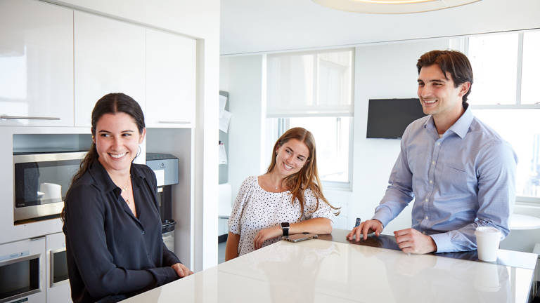 2 Female 1 Male Lazard Colleagues in Pantry Laughing