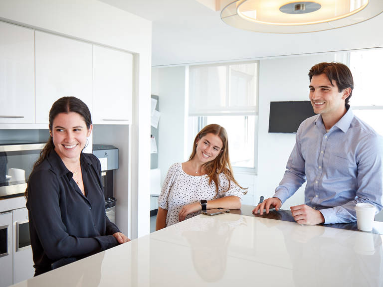 2 Female 1 Male Lazard Colleagues in Pantry Laughing