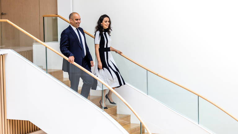 Male and Female Lazard Colleagues Walk Down Set of Stairs