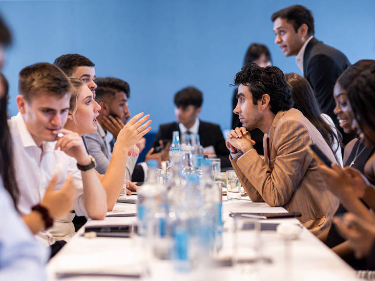 Group of Lazard Interns Talking at Long Table